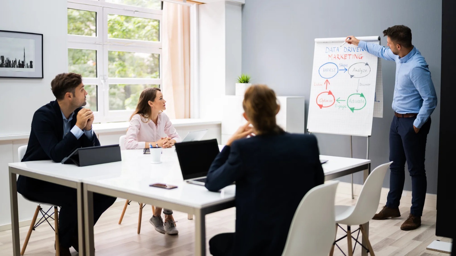 Formateur présentant devant un tableau de conférence à un groupe de professionnels en session de formation